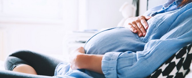pregnant woman holding stomach