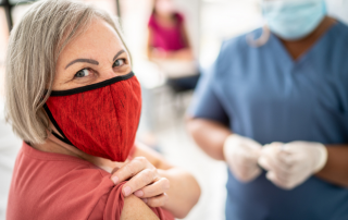 women wearing mask with bandage on arm after vaccine