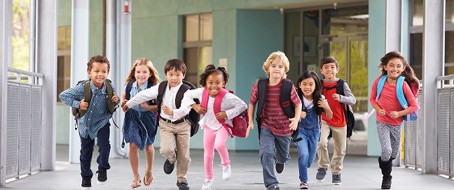 Group of elementary school kids running in a school corridor