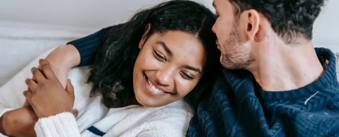 a young couple (woman and man) embracing and smiling together