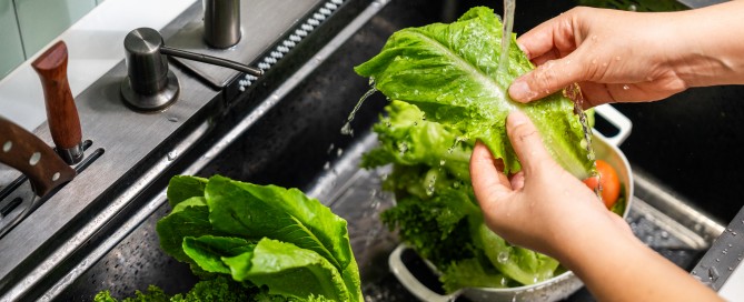 washing a leaf of lettuce in the sink
