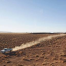 truck driving through dusty desert road